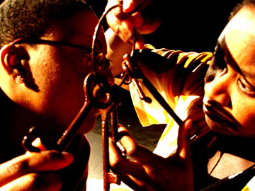 Anita and Tabitha look at each other through a set of keys