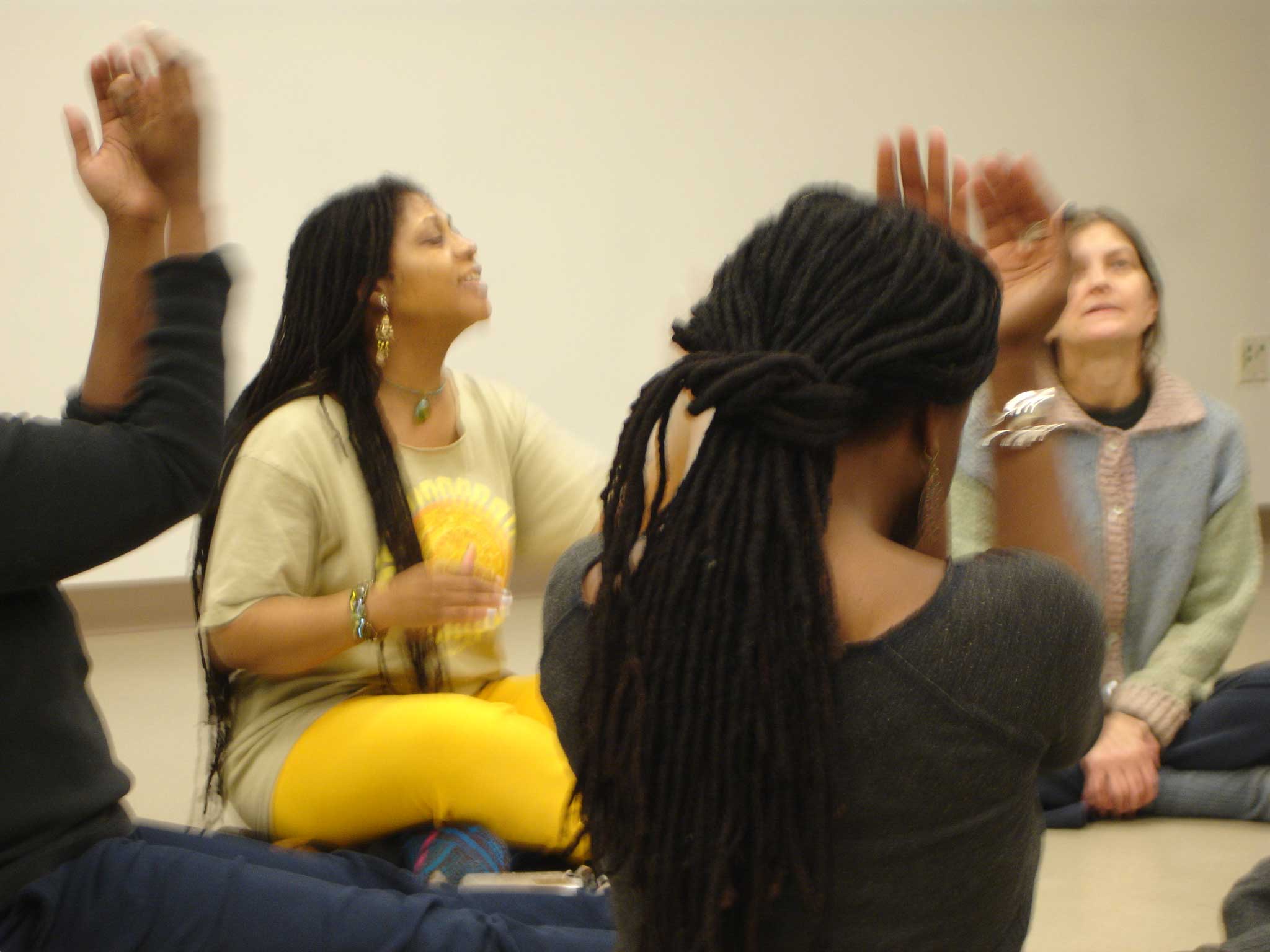 Tiye leading a song workshop,people in the round using hands and voices to create their song